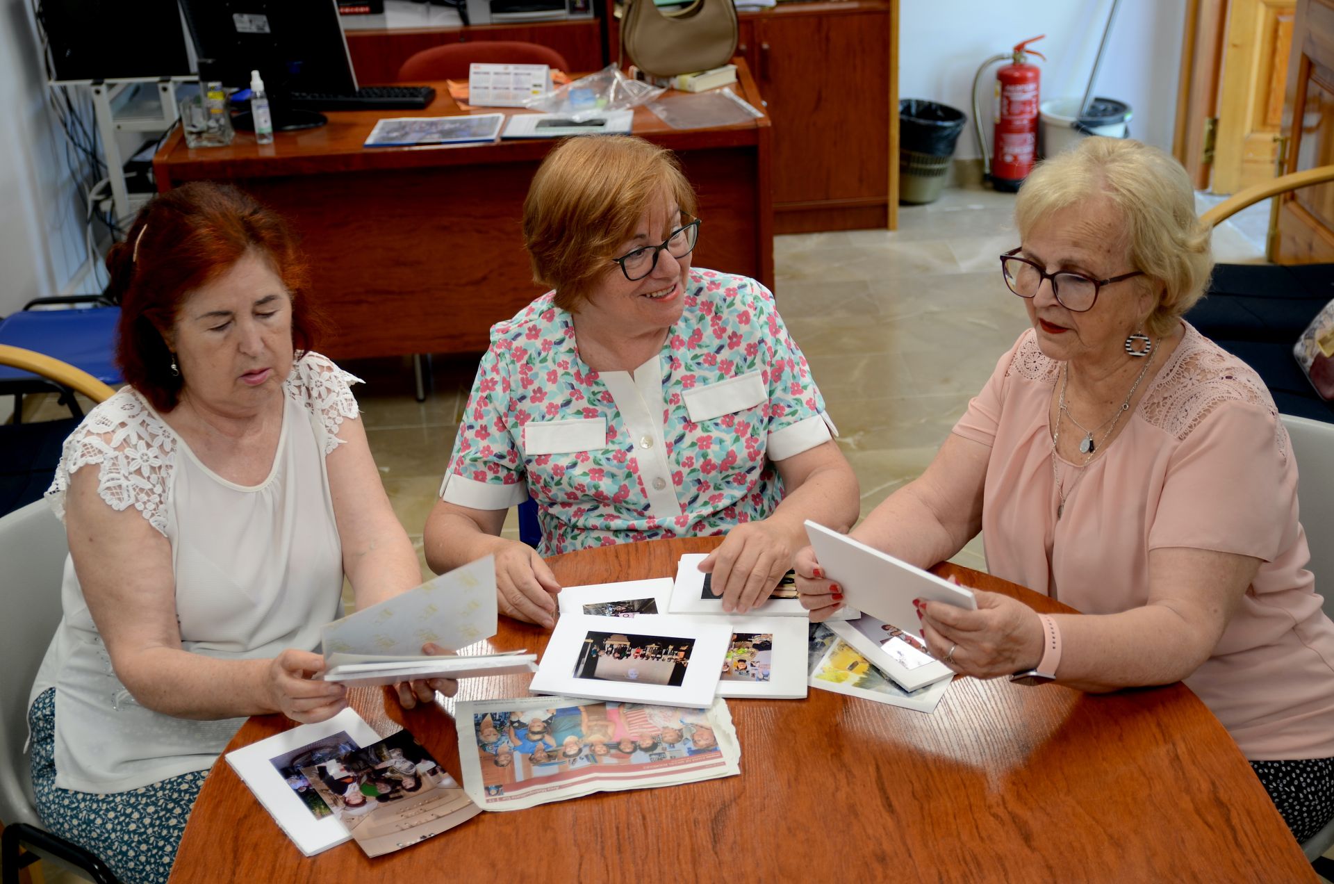 María Angustias Lafuente, Juana de Miguel y Encarnita Jiménez, repasando fotos y recortes en su sede.