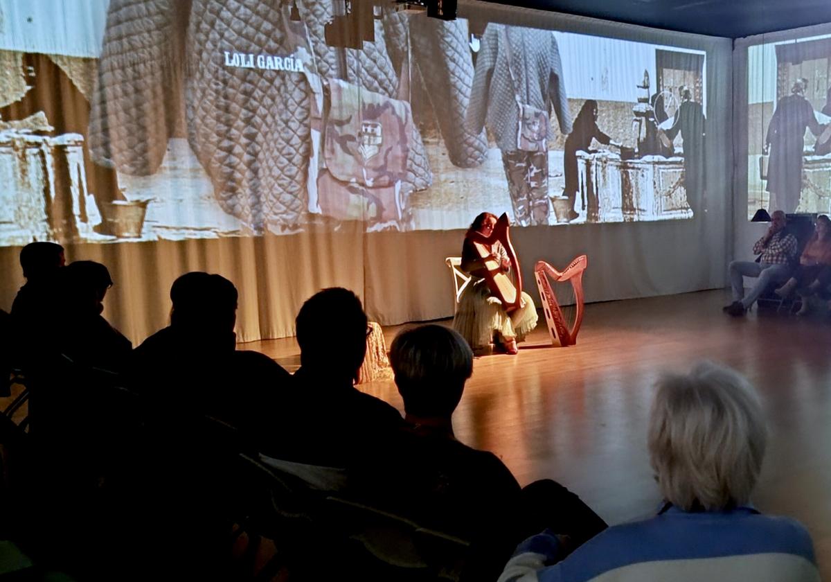 Abigail R. Horro, con dos arpas, y el público, envueltos por las proyecciones del taller de moda.