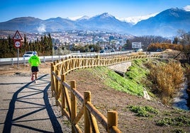 Un corredor trota junto a la barandilla del sendero que transcurrirá desde Granada hasta Monachil.