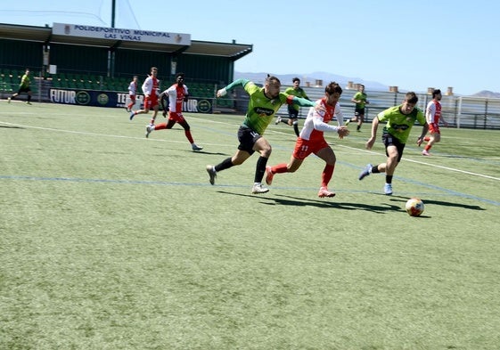 Duelo por un balón en el centro del campo del Municipal Las Viñas.
