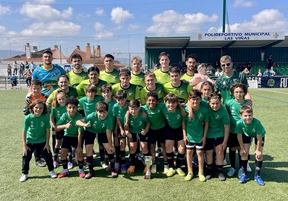 Los campeones benjamines lucen el trofeo con el primer equipo tras el pasillo de honor.