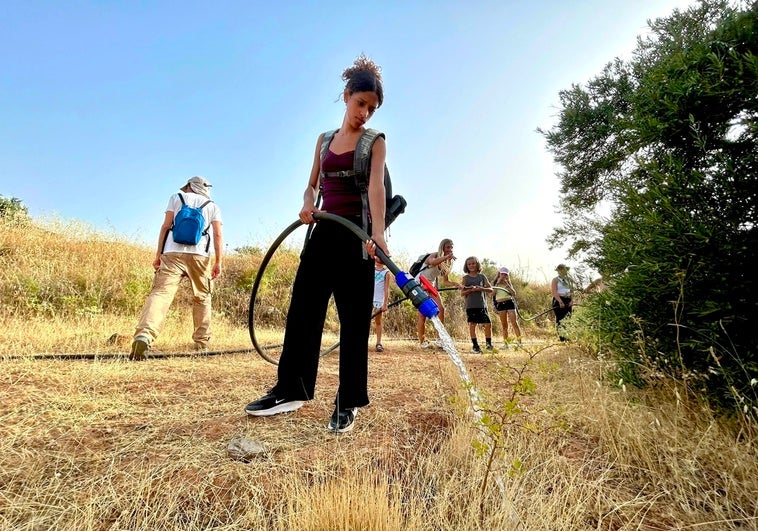 Una joven estadounidense participa en las labores de riego en el Camino de los Neveros.