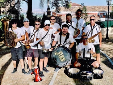La Charanga Vaso Largo, con las camisetas que conmemoran su vigésimo aniversario, en las fiestas de San Roque 2026 de Huétor Vega.
