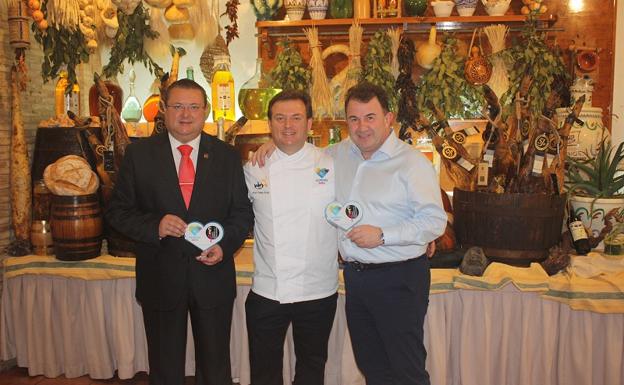 Gines y Antonio Carmona y Berasategui sostienen el distintivo de Almería 2019, Capital Española de la Gastronomía. 