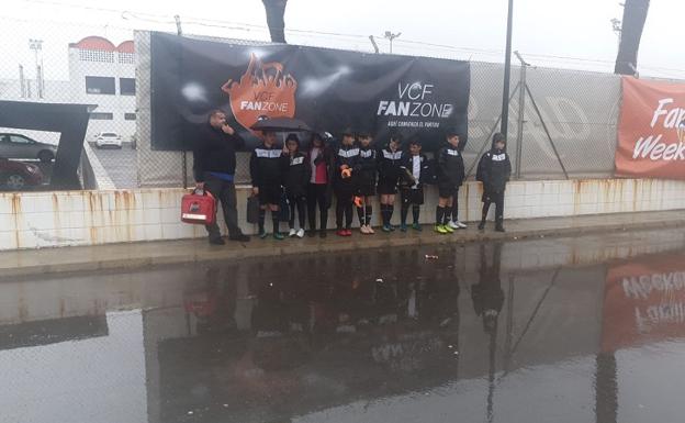 El equipo alevin de la P. D. Garrucha, esperando para disputar un partido bajo la lluvia y el temporal.