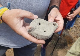 El director de las excavaciones, Julio Román, muestra una de las lucernas halladas durante las excavaciones.