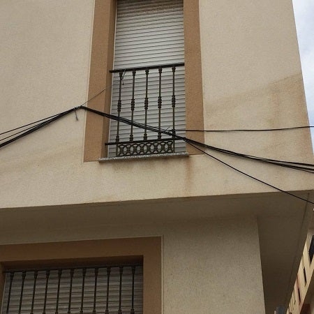 Un cableado 'pillado con cordones' a las rejas de ventanas en Garrucha