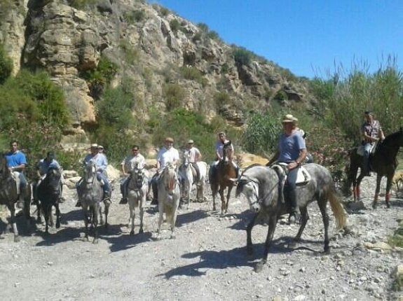 Jinetes dando un paseo a caballo por la rambla.