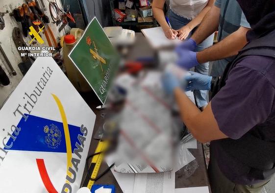 Agentes de aduanas y Guardia Civil analizan el paquete con la cocaína oculta.