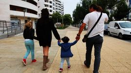 Unos padres llevando a sus hijas a dar un paseo.