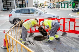 Dos operarios revisando las redes de alcantarillado del municipio.