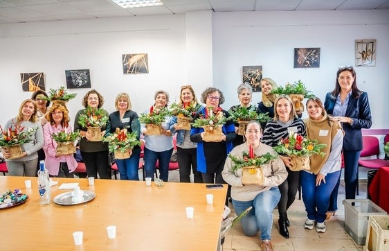 Varias mujeres presentan sus decoraciones navideñas.