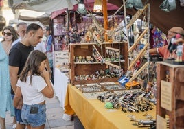 Unos vecinos miran algunos de los productos del mercado.