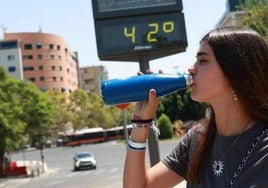 Una joven se hidratata con agua por las altas temperaturas.
