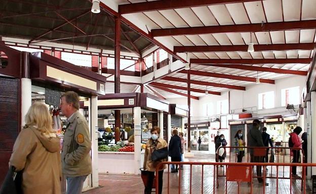 Imagen principal - Vista del interior del mercado, una pescadería y un pequeño altar a Santa Rita.