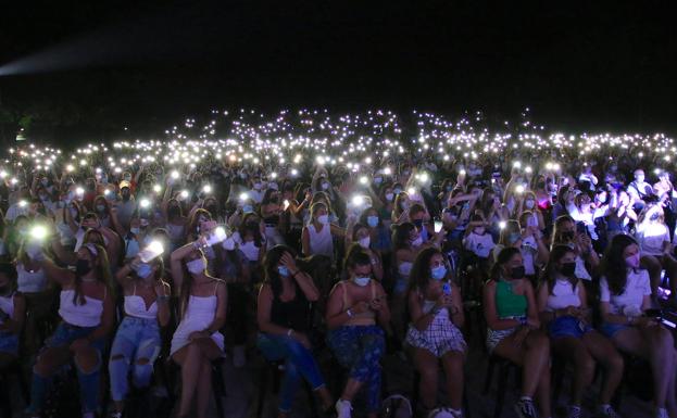 Público asistente iluminando a la artista.