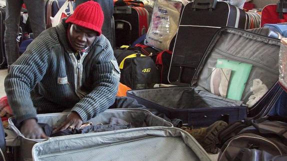Un temporero prepara las maletas.