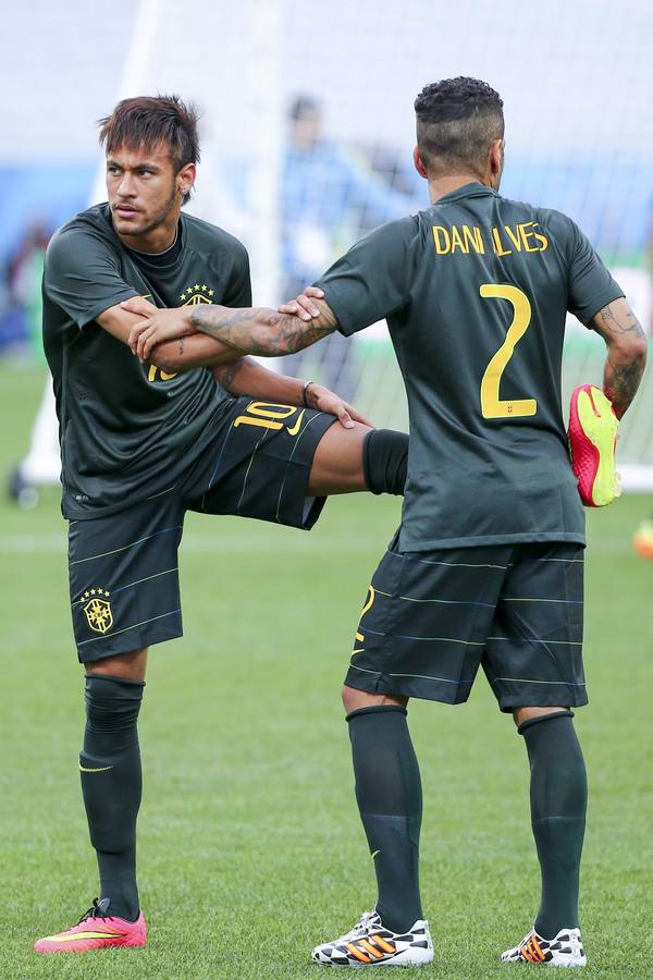 Neymar estira. El astro brasileño calienta junto con su compañero del Barcelona Dani Alves