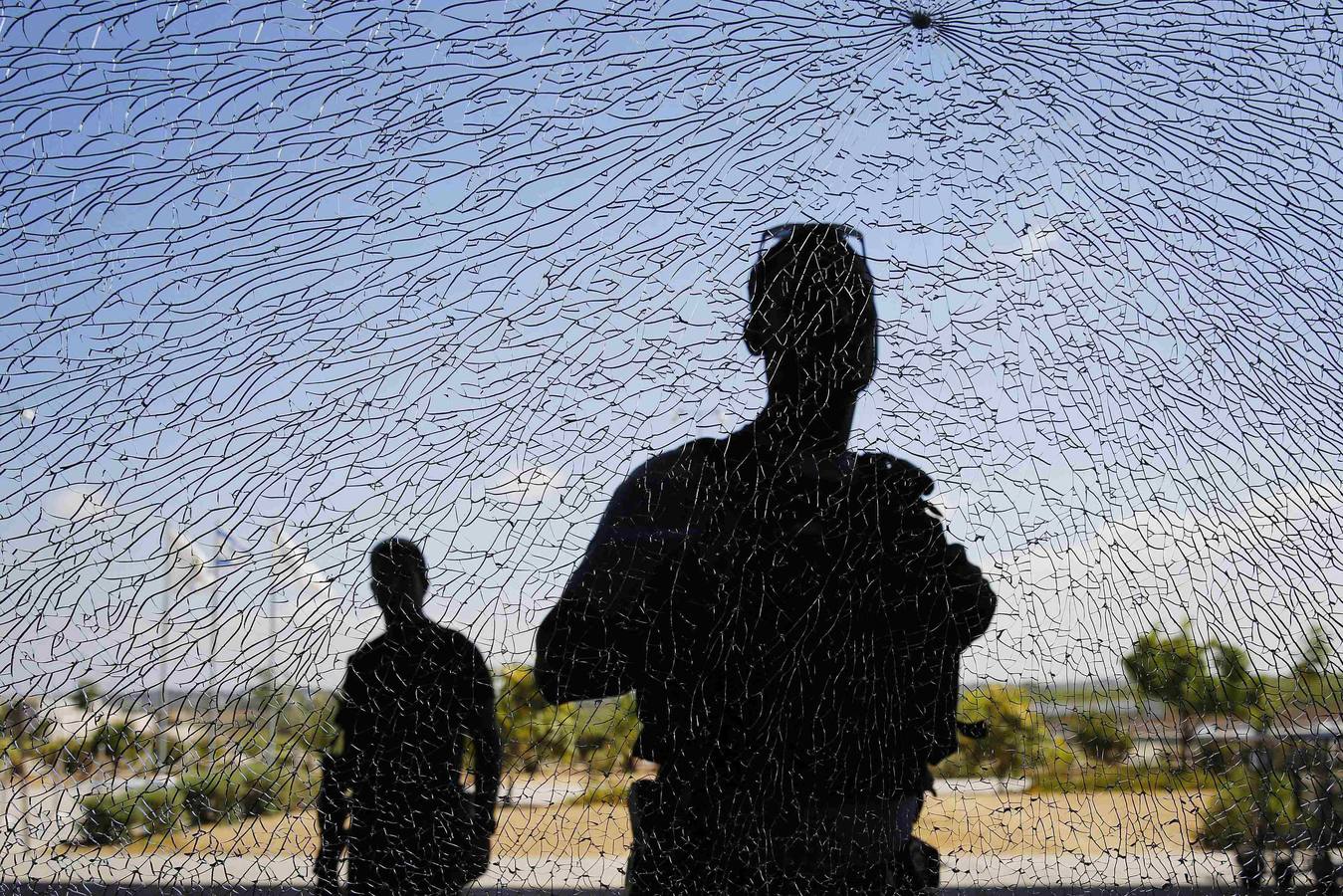 Personal de seguridad israelíes miran una ventana dañada por la metralla de un cohete de corto alcance que aterrizó el martes cerca del cruce de Erez.