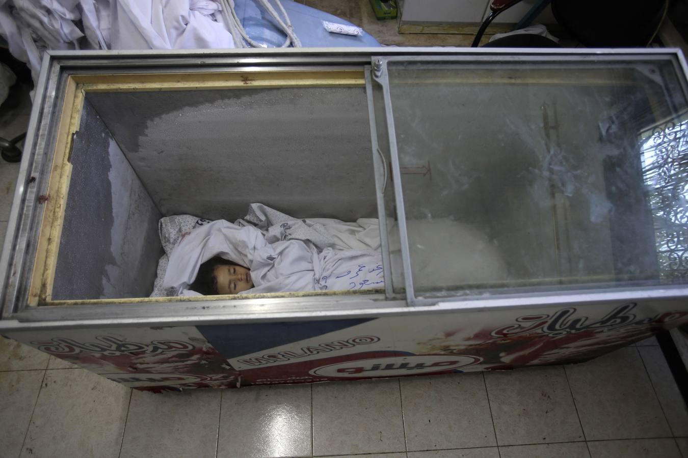 El cuerpo de una niña palestina Raghad Massoud, a quien los médicos dijeron que murió en un ataque aéreo israelí, se ve el interior de un congelador de helados en el Hospital de Kuwait, que no dispone de un depósito de cadáveres, en Rafah, en el sur de la Franja de Gaza.