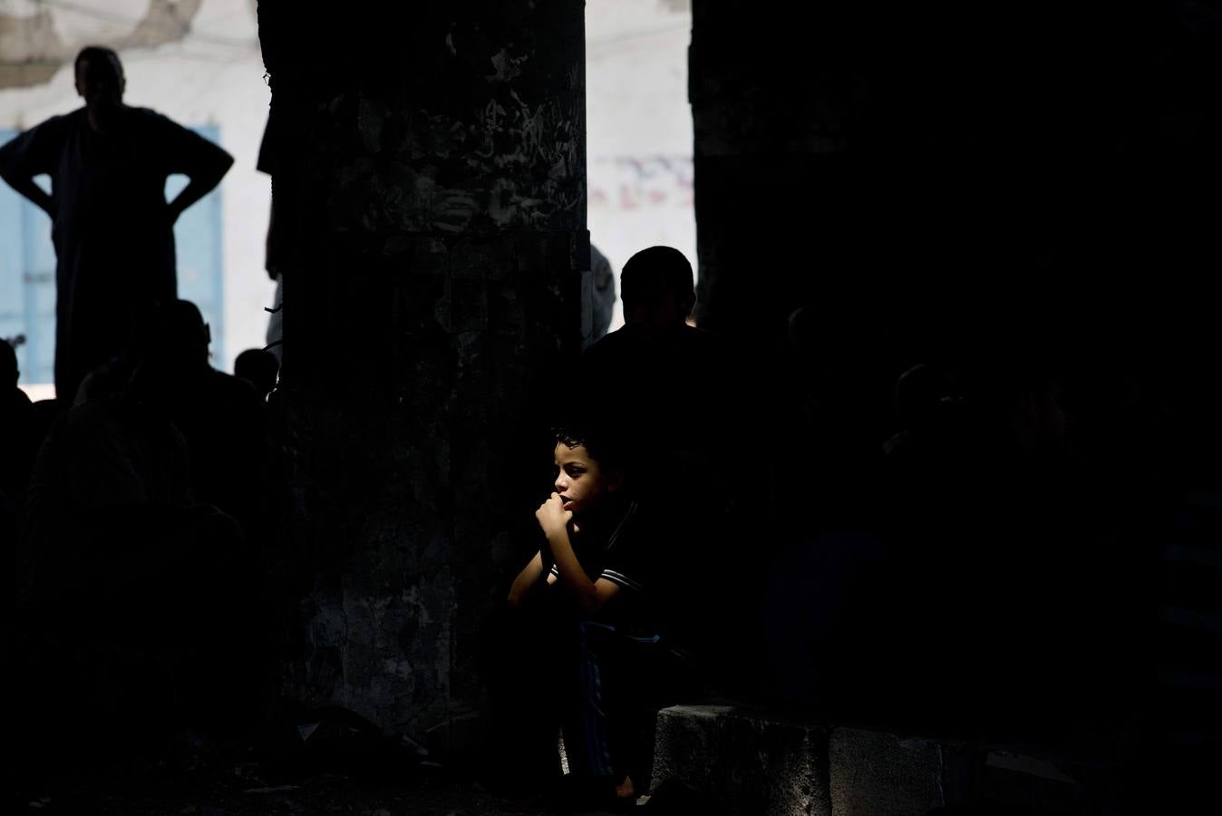 Un niño palestino se encuentra en un bloque de cemento dentro de una mezquita parcialmente destruido.