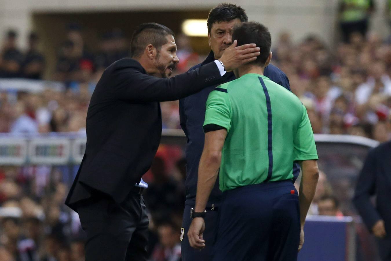 Simeone habla con el árbitro, junto al 'Mono' Burgos, antes de ser expulsado.