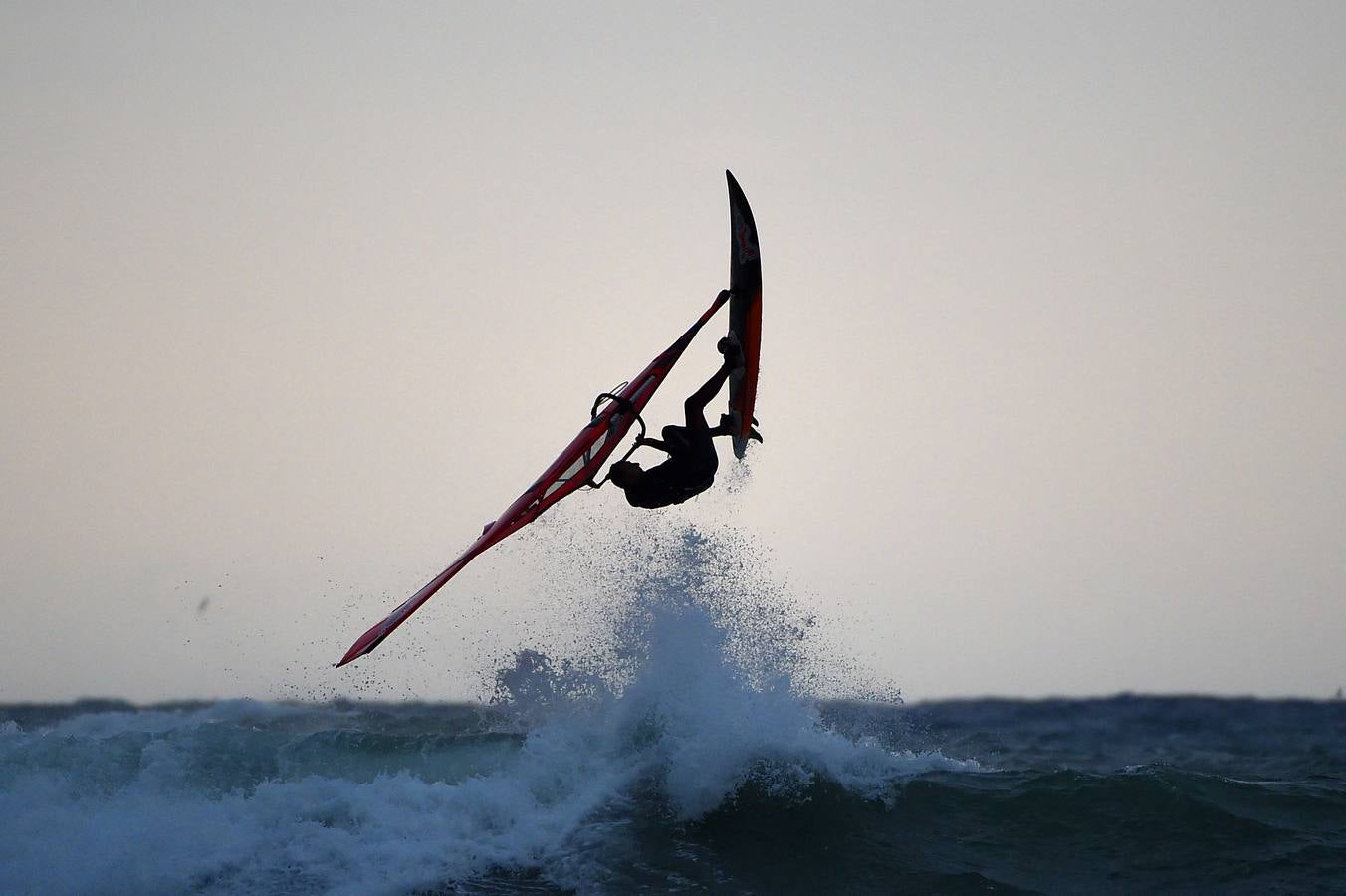 Un windsurfista salta en la costa norte de Italia en Aurelia.