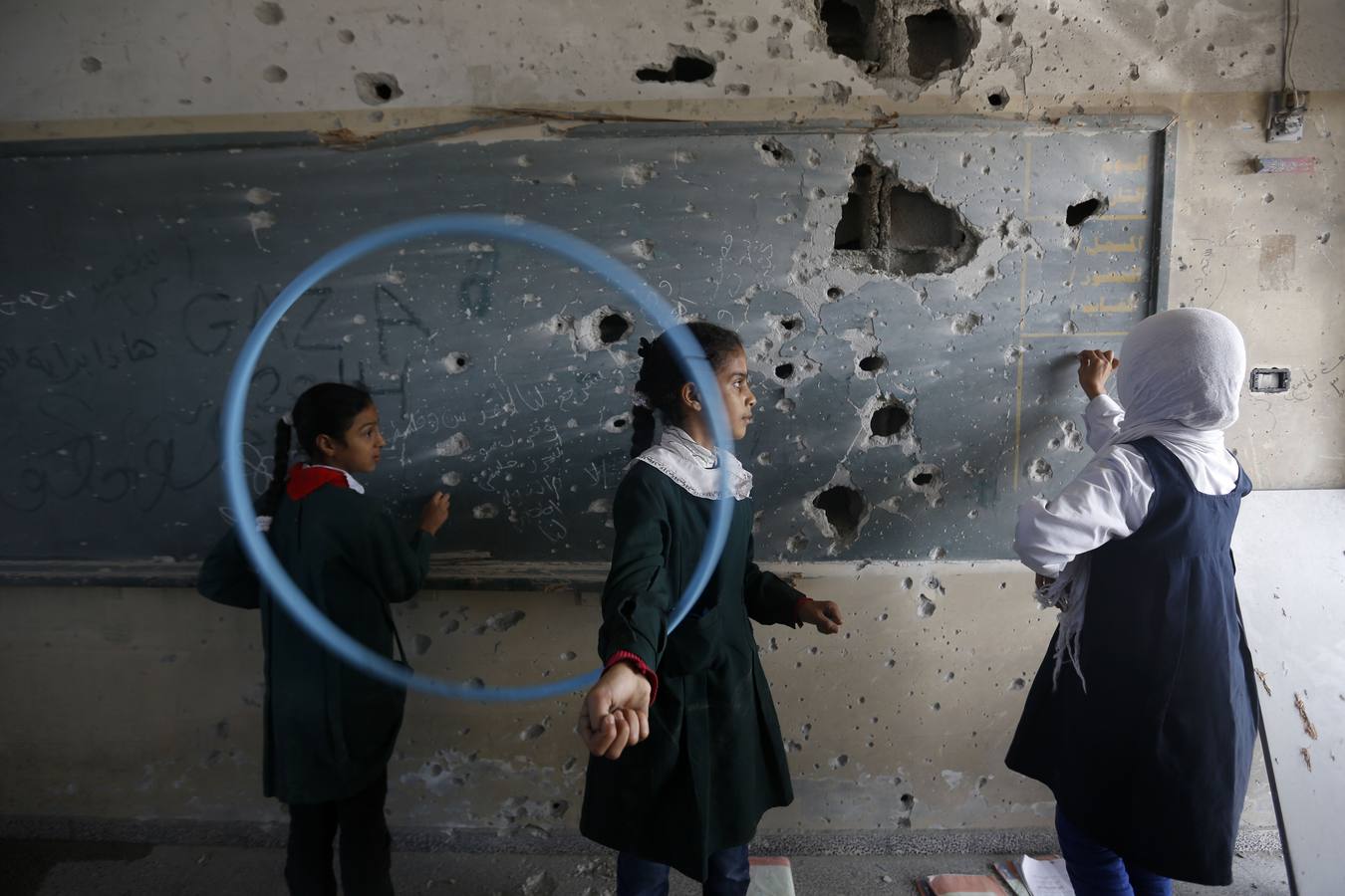 Niñas palestinas juegan dentro de su escuela que fue destruida durante los 50 días de conflicto entre Israel y Hamás el pasado verano.