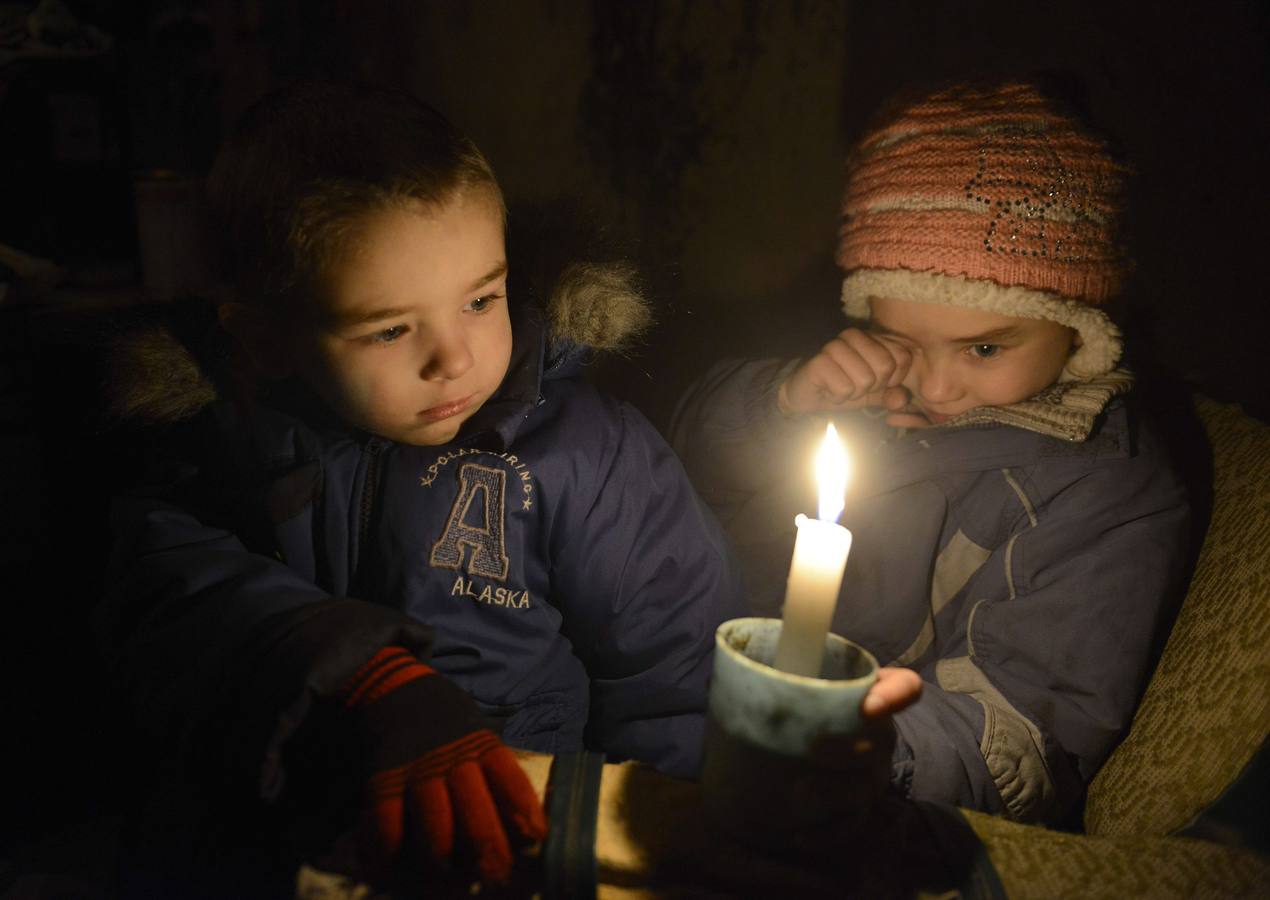 Dos niños sostienen velas en una bodega refugio antiaereo en Donetsk.