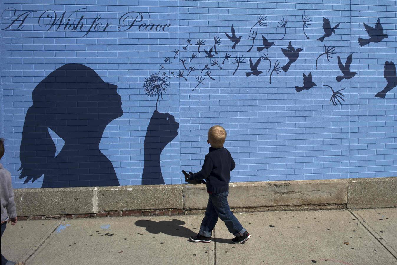 Un niño mira un mural "Un deseo para la paz" en Massachusetts.
