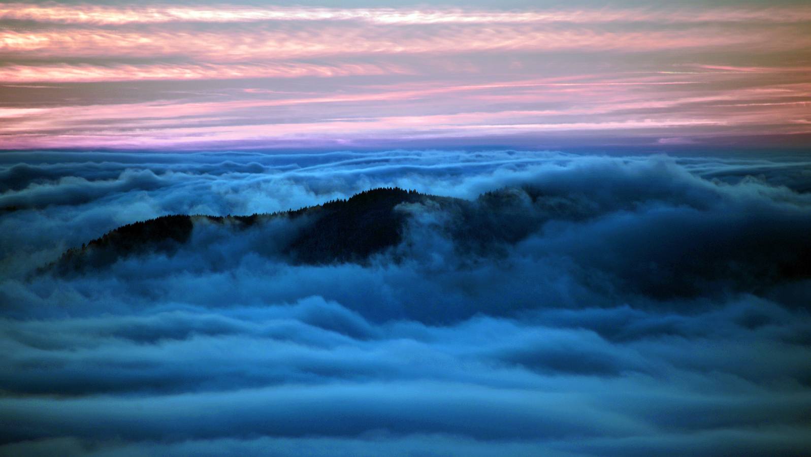 Nubes sobre las colinas cubiertas de nieve en Belmont, Francia.