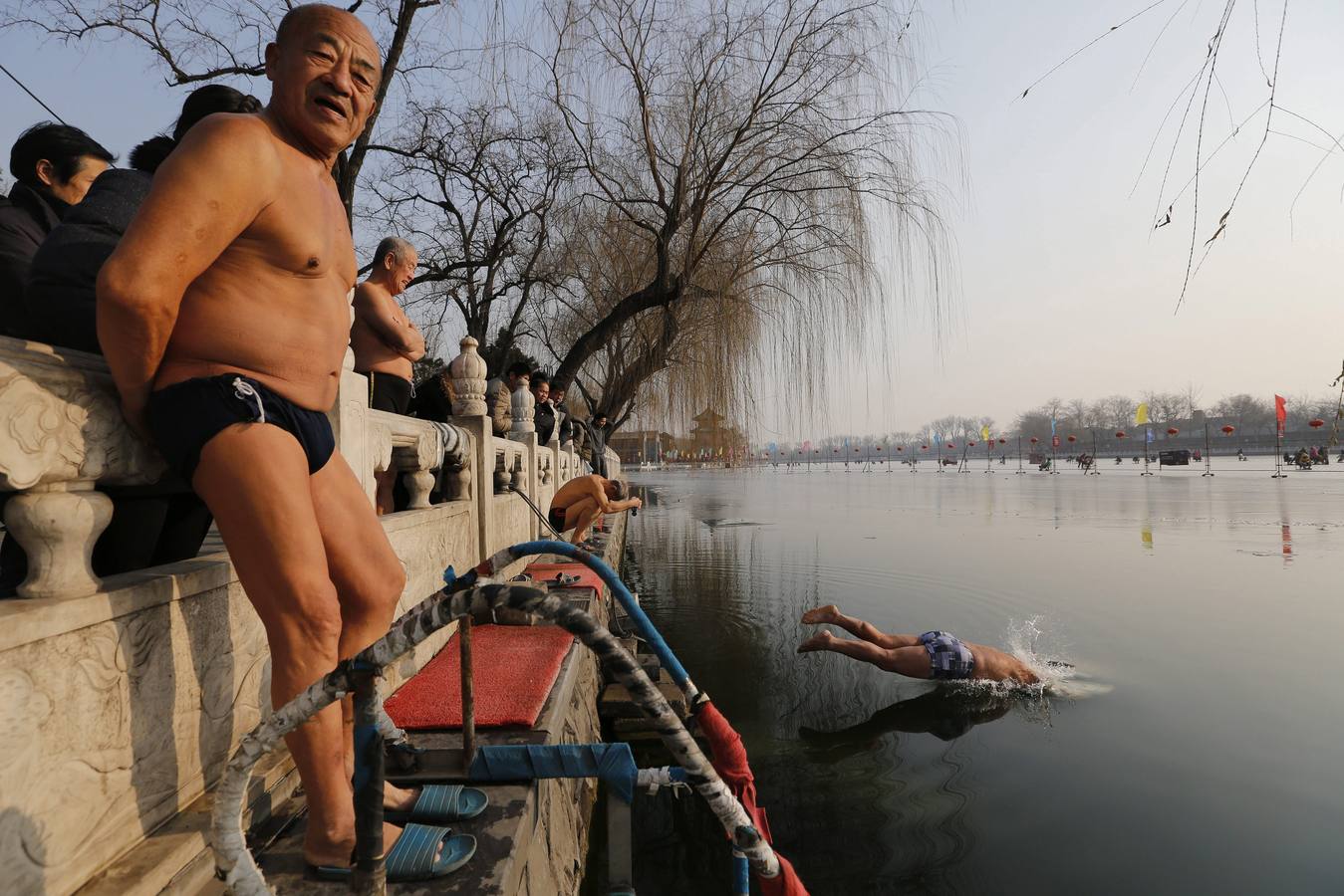 Varias personas se bañan en las gélidas aguas del lago Houhai en Pekín (China). Muchas personas consideran que bañarse en agua fría mejora notablemente el metabolismo y el sistema cardíaco.