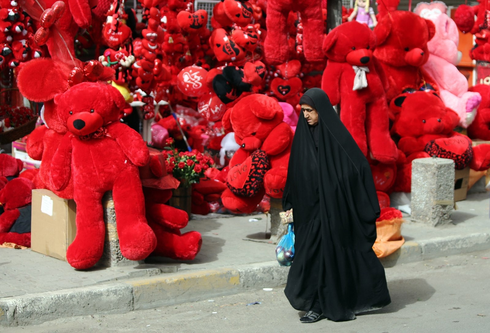 Una mujer iraquí pasa junto a una tienda de osos de peluche.