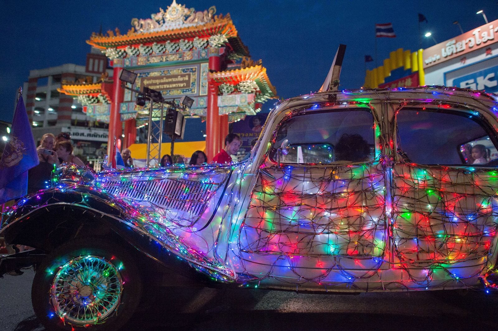 El propietario del coche con luces de colores como decoraciones para el próximo Año Nuevo Lunar, pasa a lo largo de una calle en la zona de Chinatown de Bangkok.