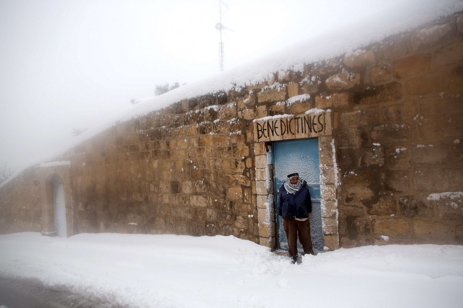 Un hombre Palestino está en la nieve en el este de Jerusalén.