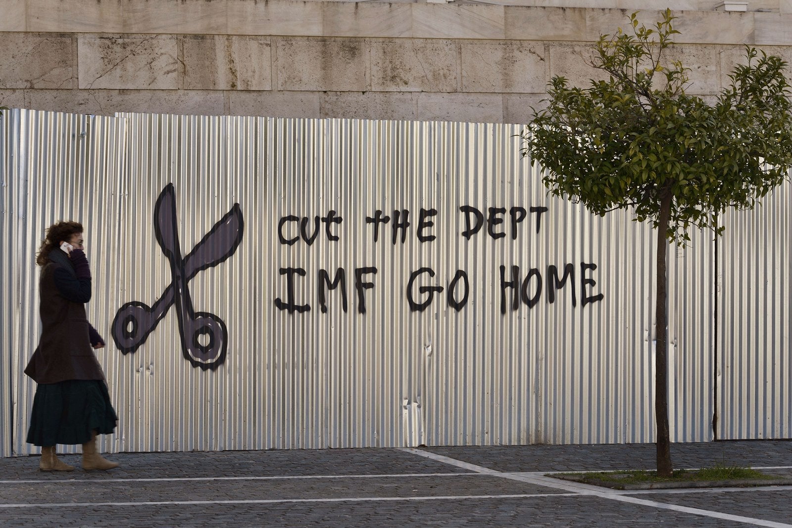 Una mujer pasa por un graffity en el centro de Atenas.