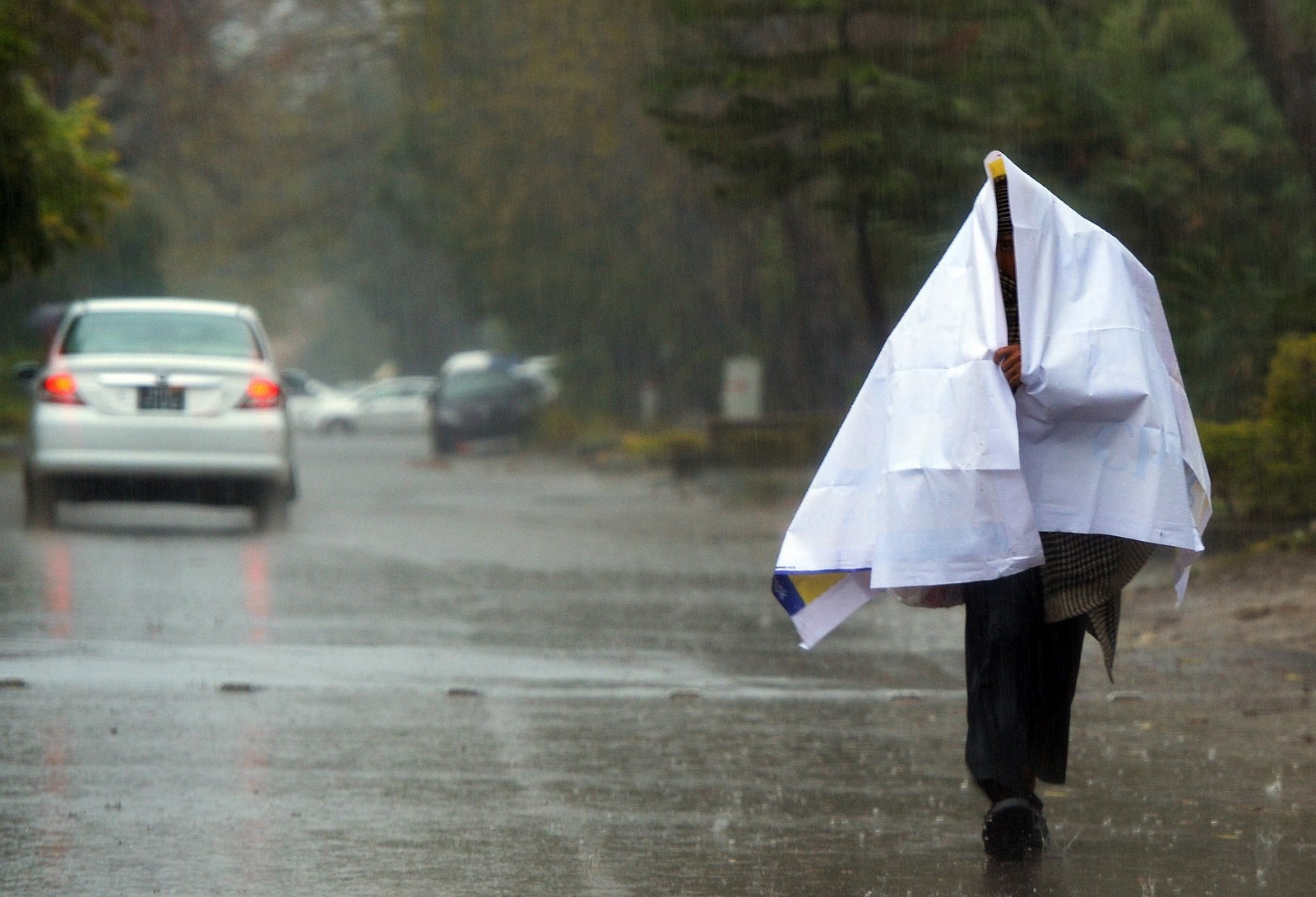 Un paquistaní se refugia de la lluvia en Islamabad.