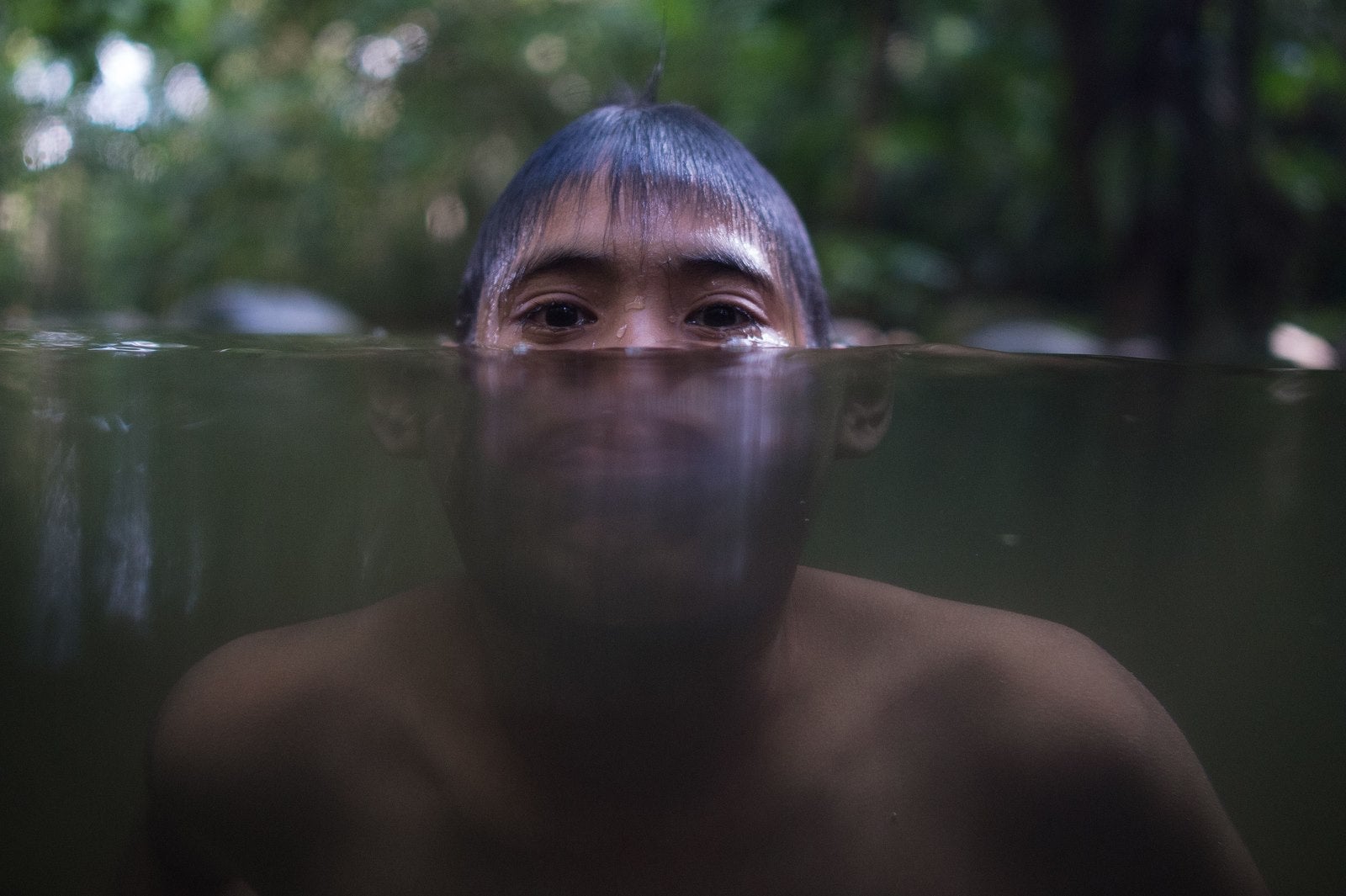 Un joven de Malasia se enfría en un río debido.