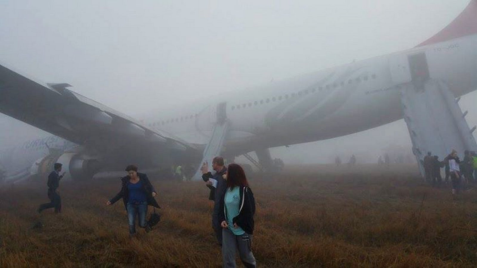 Pasajeros caminan lejos de un avión de Turkish Airlines después de que salió de la pista al aterrizar en el aeropuerto de Katmandú.