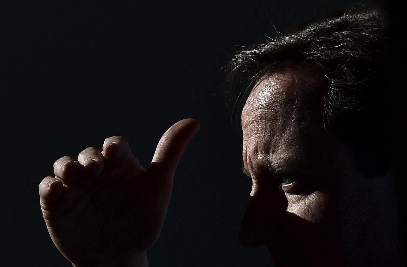 El primer ministro británico, David Cameron, protege sus ojos del sol.