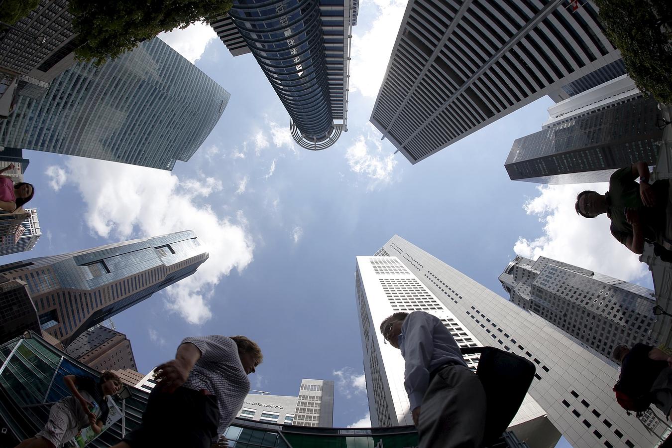 La gente camina más allá de edificios de oficinas en el distrito central de negocios en Singapur.