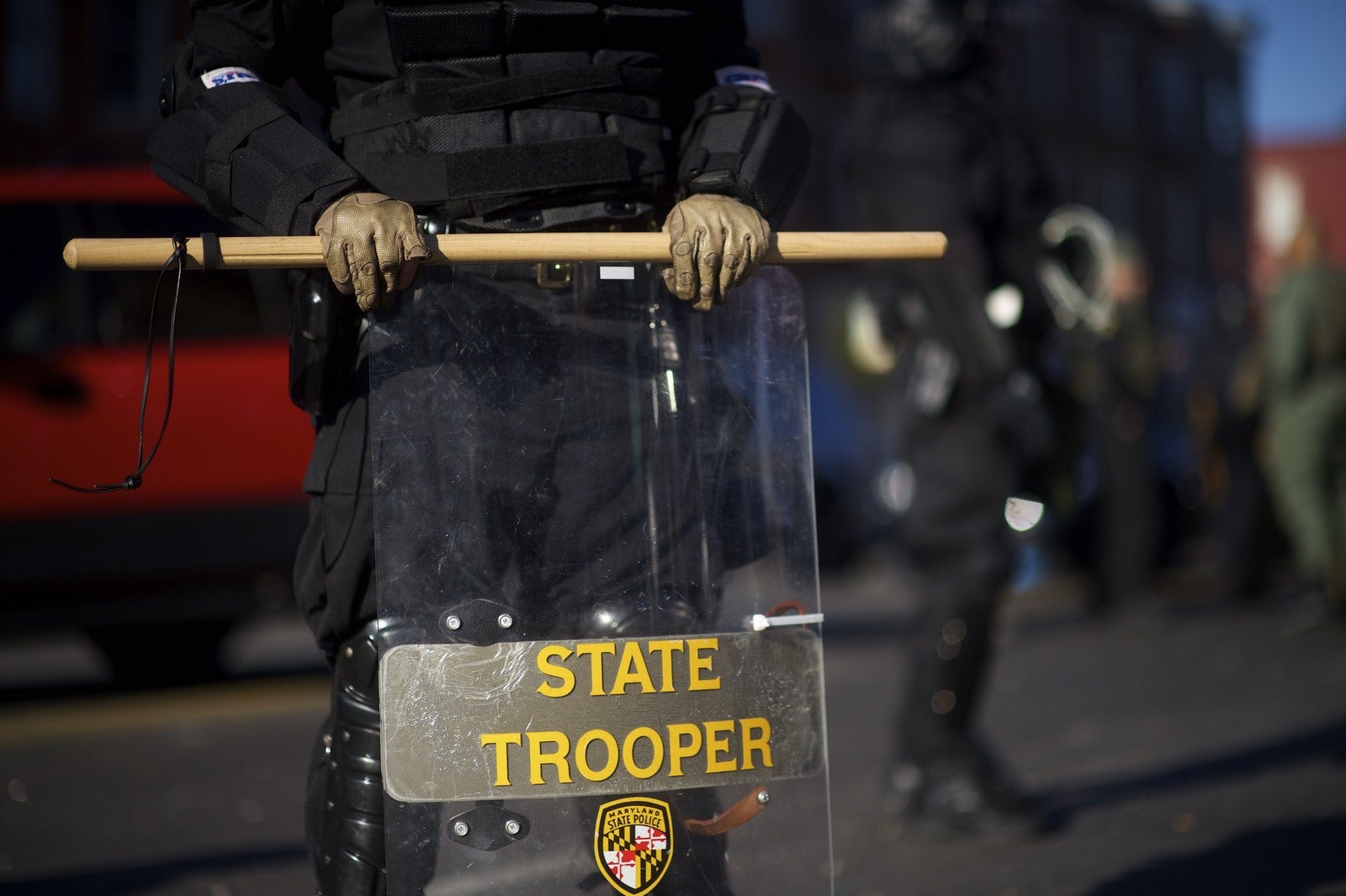 La policía de Baltimore vestidos con uniformes antidisturbios y miembros de la Guardia Nacional de la línea de la calle, mientras el gobernador de Maryland Larry Hogan visita la escena después de los disturbios en toda la ciudad tras el funeral de Freddie Gray.