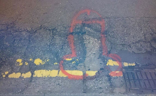 Un artista anónimo pinta penes en los baches para que sean arreglados y lo consigue