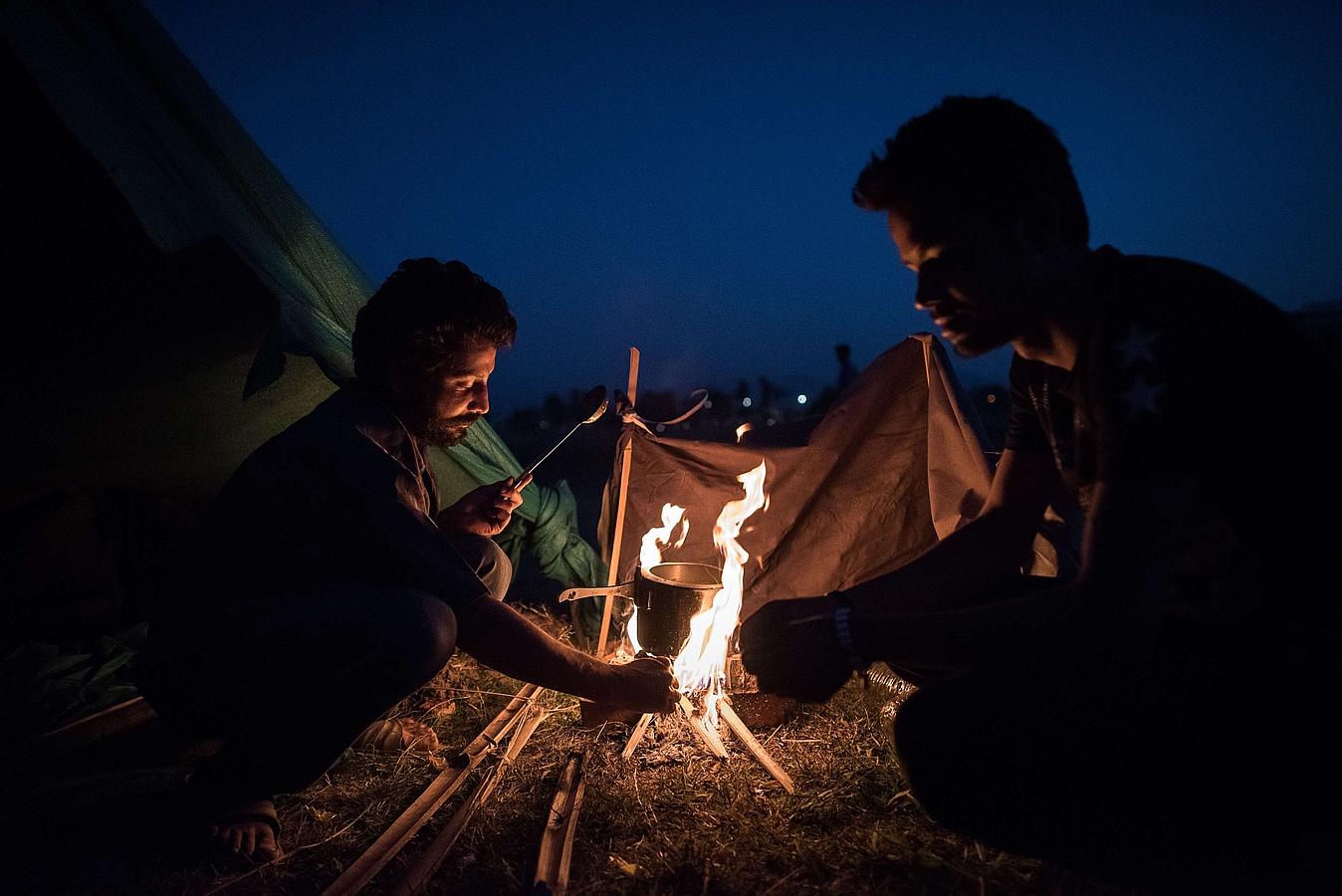 Sobrevivientes del terremoto preparan comida antes de pasar la noche junto a un refugio en Katmandú.