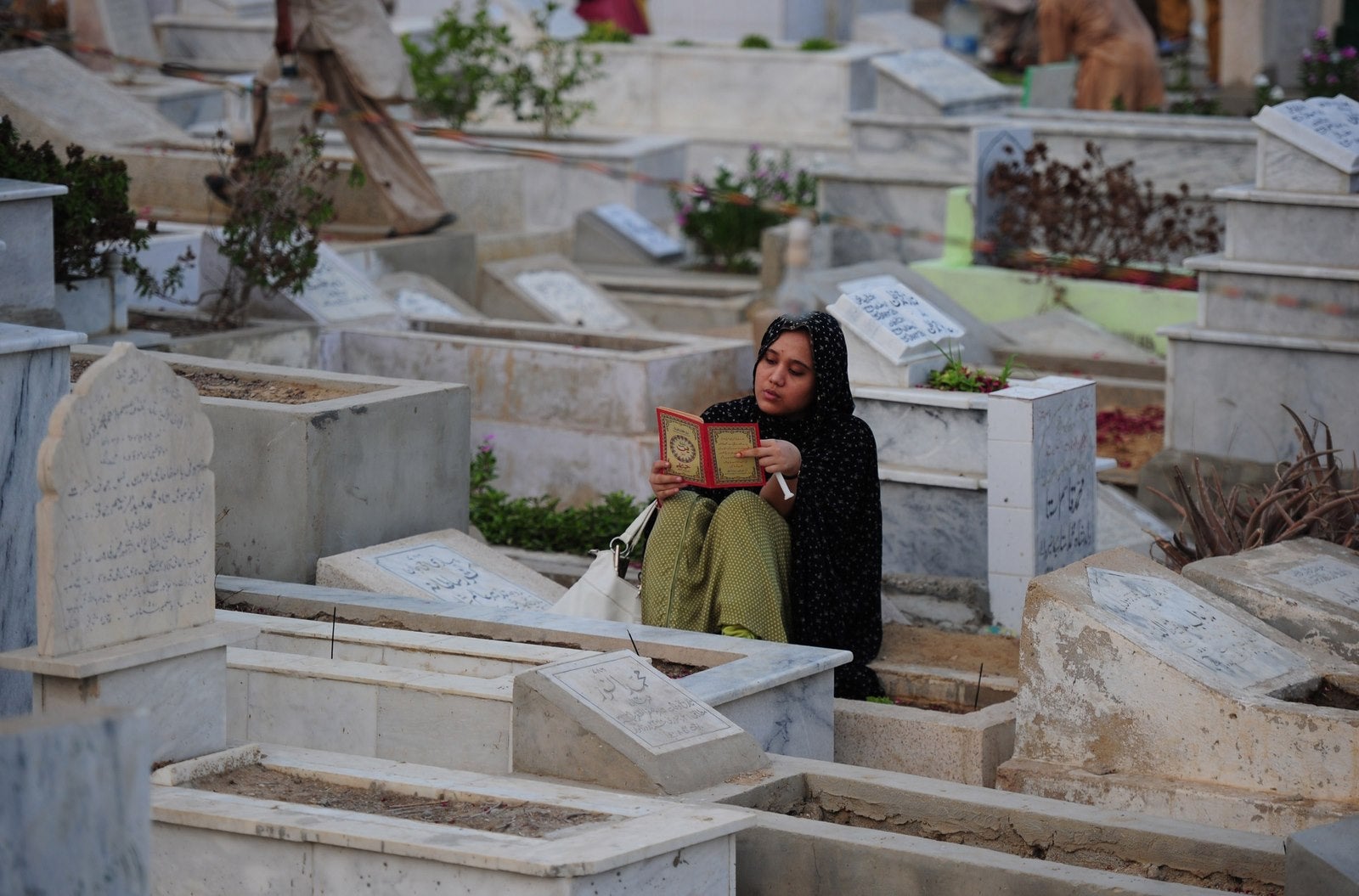 Una musulmana paquistaní recita el Corán junto a las tumbas de los familiares para marcar Shab-e-Barat durante la noche del perdón en Karachi.
