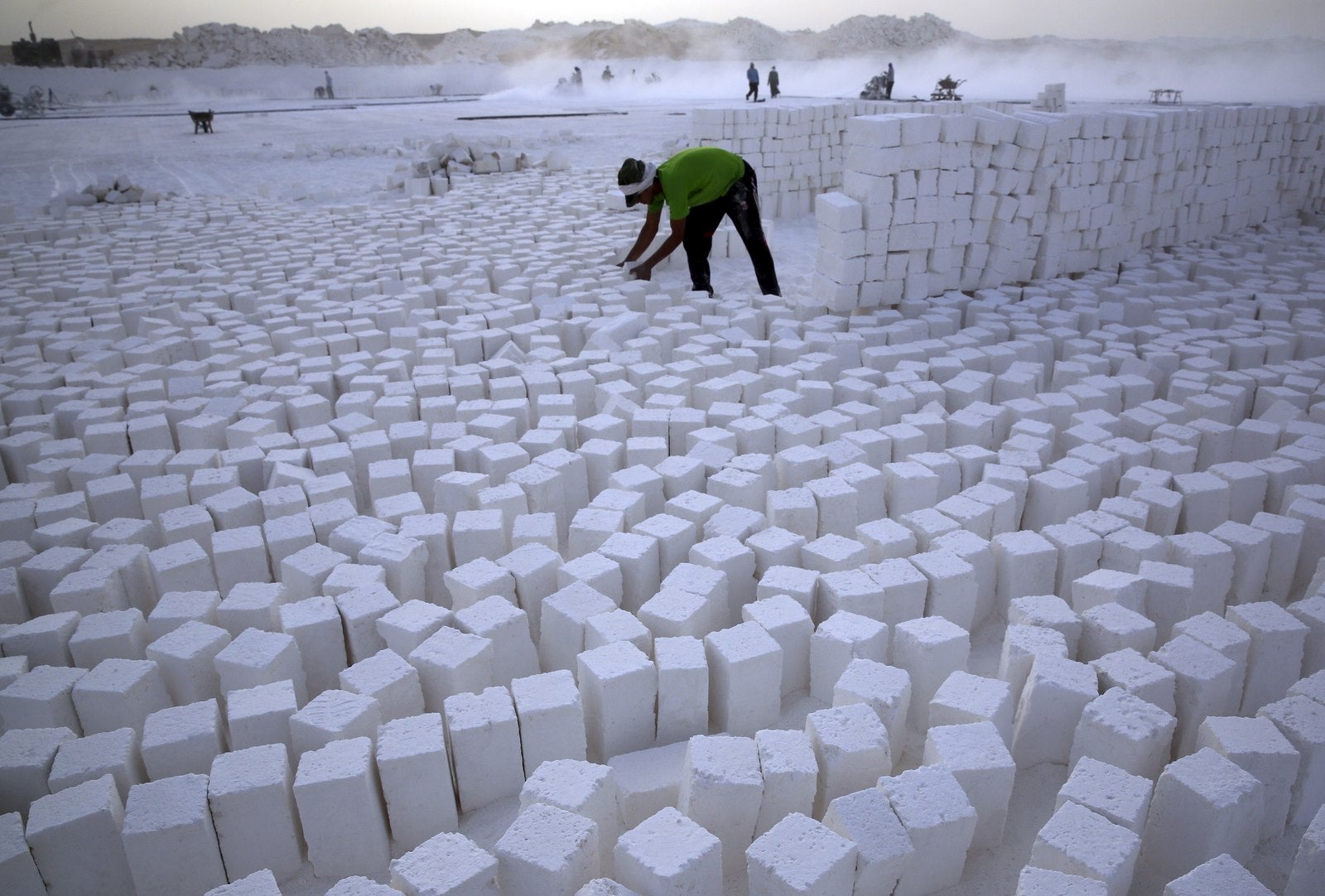 Un trabajador apila ladrillos en una cantera en el desierto de Minya, al sur de El Cairo, Egipto .
