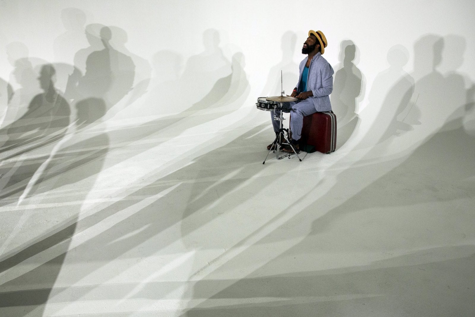 Un baterista toca entre las sombras de los modelos en la presentación de la Semana de la moda de hombres, en Nueva York.