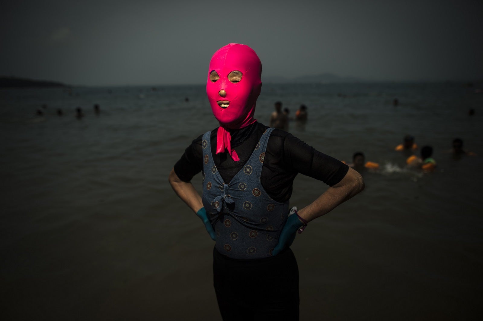 Una mujer con un facekini en la playa en Qingdao, provincia de Shandong, este de China.