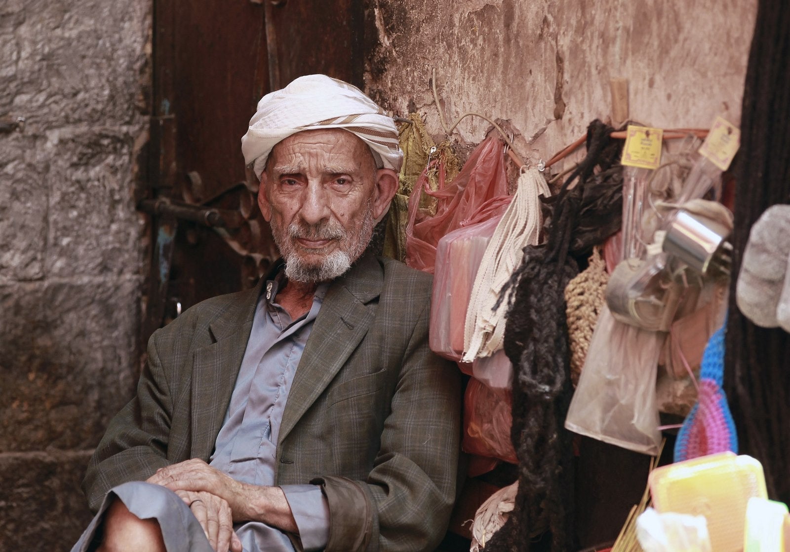 Un yemení se sienta en un puesto en un mercado de la capital de la ciudad vieja de Sanaa.