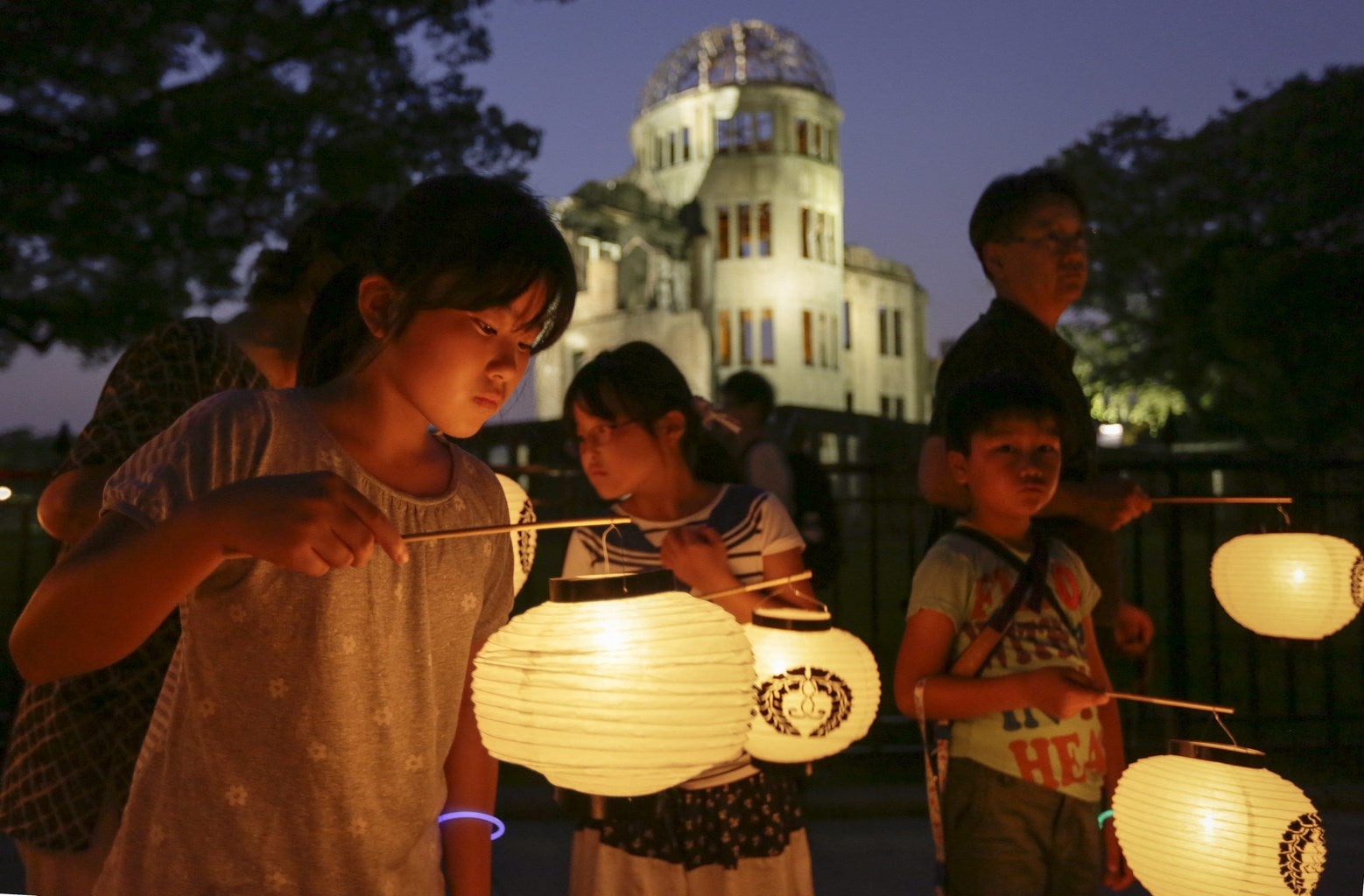 Varios niños de Hiroshima llevan linernas durante una procesión para confortar las almas de las víctimas de la bomba atómica ante la Cúpula de la Bomba Atómica, en el Parque Conmemorativo de la Paz de Hiroshima.